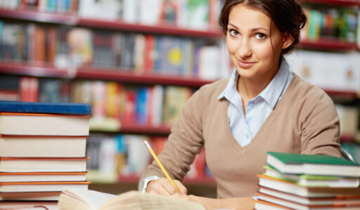 Portrait of clever student working in college library